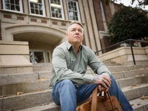 Eric Dunaway sits on the steps of the Rhyne Building